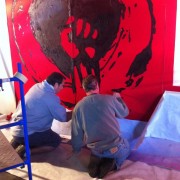 TRIO hand-painting the backdrop for Rise Against