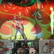 Poison on stage with TRIO hand-painted backdrop in Dallas
