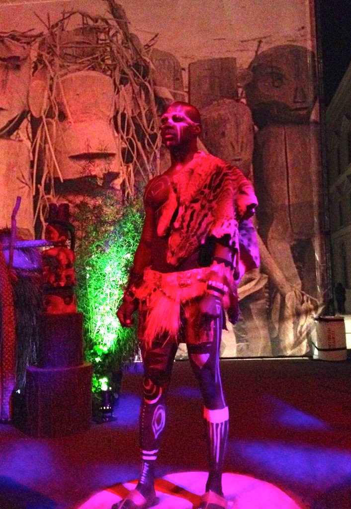 TRIO printed graphics in the background, tribal body paint on model at Warner Bros LA Screenings Gala, on the Warner Bros studio lot, in Burbank.